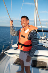 Mature man in a life jacket on a yach feeling good