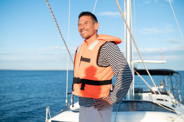 Mature man in a life jacket on a yach feeling good