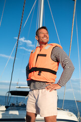 Mature man in a life jacket on a yach feeling good