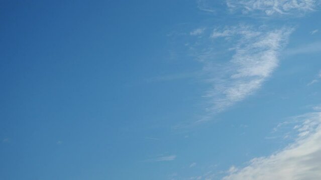 Beautiful blue sky with light clouds background. Natural autumn sky. Delicate hue paints the atmosphere with sense of tranquility. Sunny day travel. Weather forecasting. Real time. Slow motion