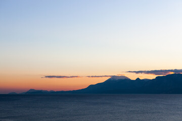 Mediterranean sea and mountains view from Antalya, Turkey waterfront park at sunset.