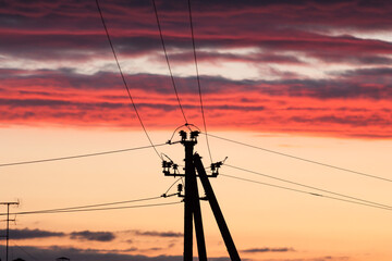 Electric line against colorful sky at sunset