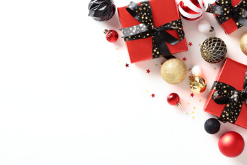 Christmas composition. Flat lay red gift boxes with black ribbon bows, glitter balls, decorations...