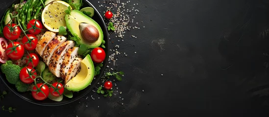 Poster Grilled chicken quinoa spinach avocado brussels sprouts tomatoes cucumbers in a healthy buddha bowl viewed from the top on a dark gray background Copy space image Place for adding text or desig © vxnaghiyev
