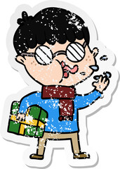 distressed sticker of a cartoon boy wearing spectacles with christmas gift