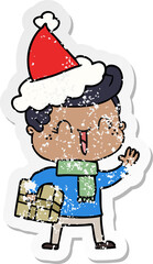 hand drawn distressed sticker cartoon of a laughing boy wearing santa hat