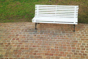 White Colored Wooden Bench on the Stone Paved way in a Garden