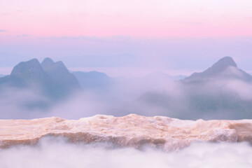 Surreal stone podium outdoors on clouds in soft blue sky pink pastel misty mountain nature...
