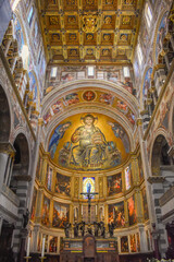 Fototapeta na wymiar Pisa, Italy - November 24, 2023: View of the apse with Mosaic of Christ Pantocrator with gilded coffered ceiling above inside the Primatial Cathedral of Santa Maria Assunta