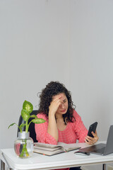 vertical image worried woman working with her laptop and cell phone in her home office