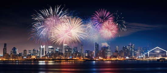 Fototapeta premium Colorful Fireworks over City skyline long exposure with beautiful dark blue sky