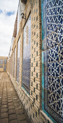 Facing the facade of a building with ancient glazed ceramic tiles in the ancient city of Khiva in Khorezm