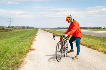 athletic senior cyclist with a gravel touring bike on a levee trail along Chain of Rocks Canal near...