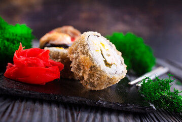 Sushi roll with salmon, smoked eel, avocado, cream cheese on black background. Sushi menu. Japanese food.