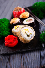 Sushi roll with salmon, smoked eel, avocado, cream cheese on black background. Sushi menu. Japanese food.