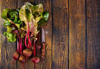 fresh beets on cutting board, set on wooden table viewed from above