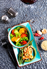 Healthy salad plate. Fresh seafood recipe. Grilled shrimps and fresh vegetable salad.