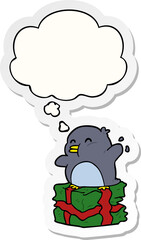 cartoon penguin on present with thought bubble as a printed sticker