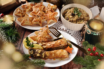 Fried carp with sauerkraut and puff pastry pies filled with mushrooms for Christmas Eve supper in Poland