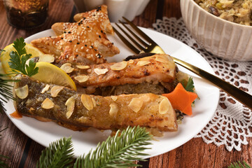 Fried carp with sauerkraut and puff pastry pie filled with mushrooms for Christmas Eve supper in Poland