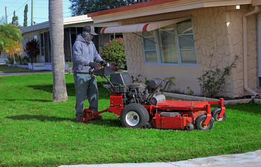 Grounds maintenance worker with walk-behind lawnmower