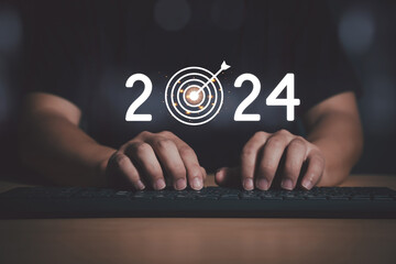 Man Finger pressing on start year 2024 button on computer keyboard with copy space. Concept of new...