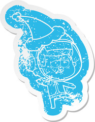 quirky cartoon distressed sticker of a tired astronaut wearing santa hat