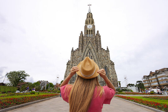 Tourism in Canela, Brazil. Rear view of tourist girl enjoying view of Our Lady of Lourdes church in Canela, Rio Grande do Sul, Brazil.