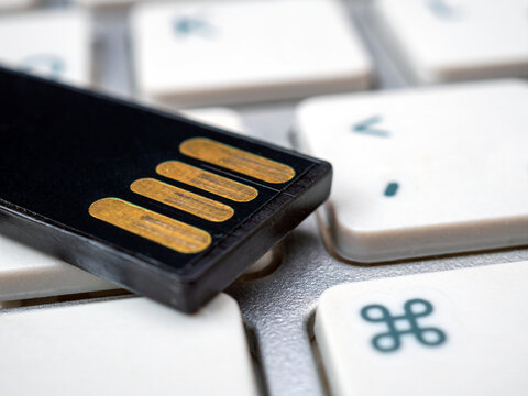 Compact memory stick on a white keyboard. Close-up