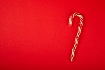 Christmas candy canes on a red background. Holiday greeting card. Concept for Christmas and New...