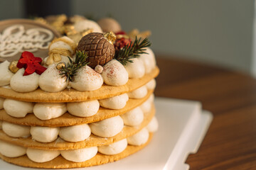 Delicious layered honey cake decorated with chocolate in the shape of Christmas tree decorations.