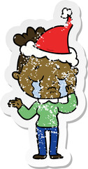 hand drawn distressed sticker cartoon of a crying woman wearing santa hat