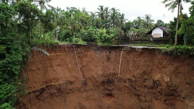 Collapsed road, camera look to brink at top of slope. Aerial shot of local landslide aftermath. Soil was saturated with water from leaking irrigation ditch, perhaps small earthquake triggered landslip