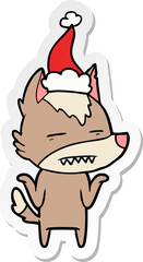 hand drawn sticker cartoon of a wolf showing teeth wearing santa hat