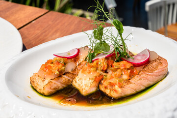 Elegant Dish Featuring Three Perfectly Placed Red Fish in Soy Sauce with Delicate Greenery Accents....