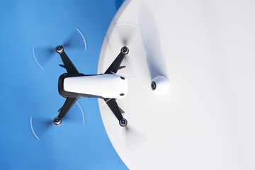 Advanced White Quadcopter Drone Soaring Against a Blue Sky Background - obrazy, fototapety, plakaty