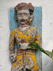 Closeup of an old weathered paint sculpture of an soldier at Maheshwar India