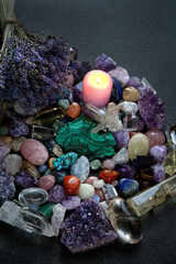 set of colorful minerals, candle, lavender flower on dark abstract background. Gemstones for magic...