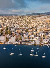 Wintermärchen am Zürichsee, Drohnen Panorama über Erlenbach, schneebedeckte Häuser, Segelboote am Ufer, klirrend kaltes Wasser unter einem tiefblauen Himmel, Winter in der Schweiz, aerial landscap