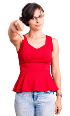 Beautiful young woman with short hair wearing casual style with sleeveless shirt looking unhappy and angry showing rejection and negative with thumbs down gesture. bad expression.
