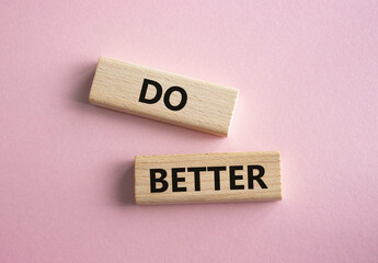 Do better symbol. Wooden blocks with words Do better. Beautiful pink background. Business and Do better concept. Copy space.