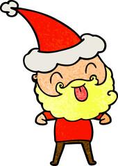 man with beard sticking out tongue wearing santa hat