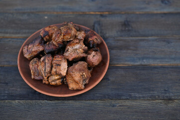 delicious grilled pork ribs kebab. rustic meat in a plate on a wooden table.
