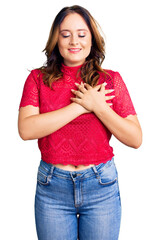 Young beautiful caucasian woman wearing casual clothes smiling with hands on chest with closed eyes and grateful gesture on face. health concept.