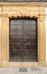 Facade of historic house with beautiful door and carved stone details in Ronda town