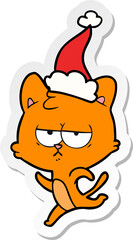 bored hand drawn sticker cartoon of a cat wearing santa hat