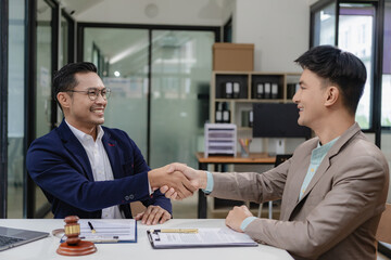 Businessman and corporate lawyer successfully shake hands in law office Lawyers and clients receive legal advice and celebrate victories.