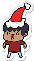 hand drawn sticker cartoon of a laughing boy wearing santa hat