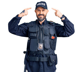 Young handsome man wearing police uniform smiling pointing to head with both hands finger, great idea or thought, good memory