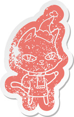 quirky cartoon distressed sticker of a cat staring wearing santa hat